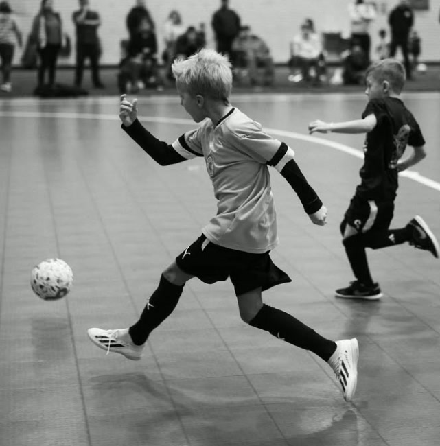 Young WCOB player striking the ball during an indoor futsal match