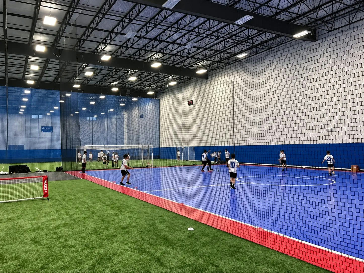 Players training across the indoor turf and futsal surfaces at Cadence Sports Center